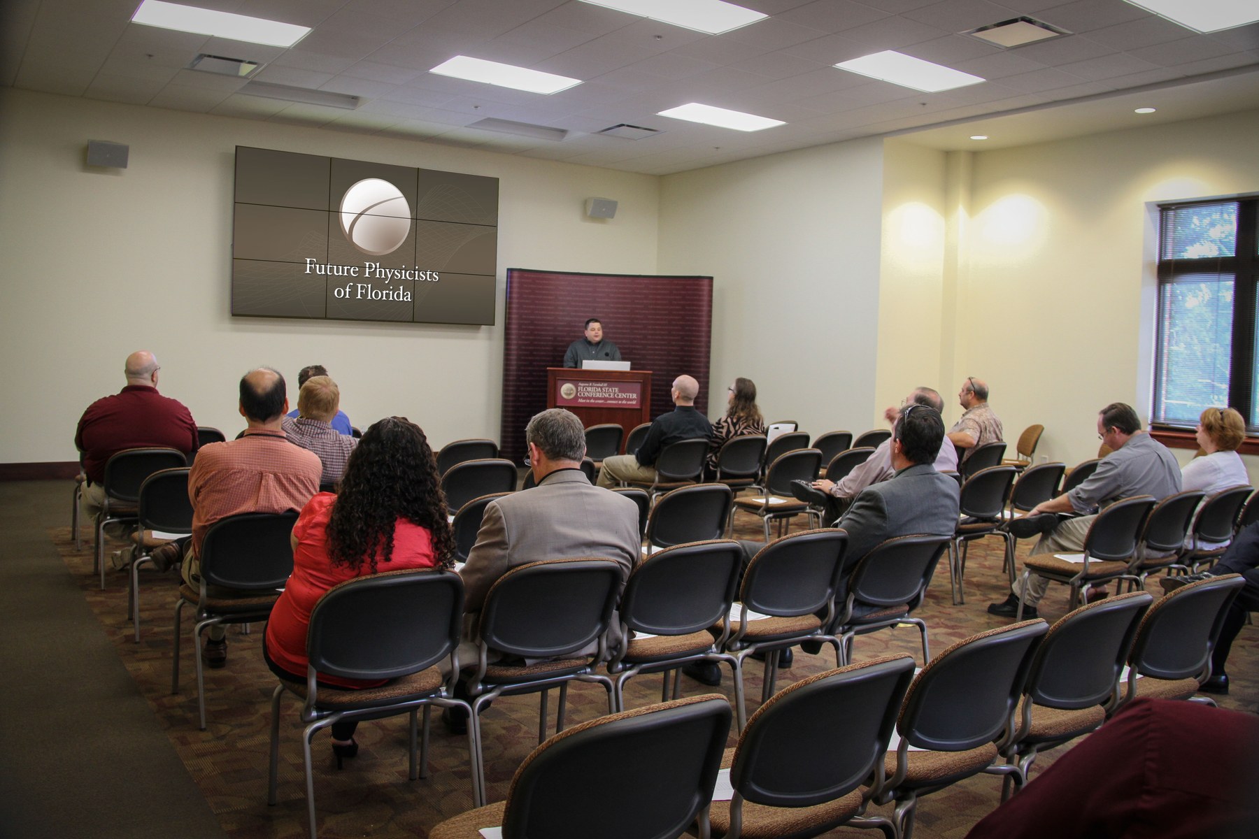 Room 214 at the Florida State Conference Center arranged in a theatre-style presentation setup